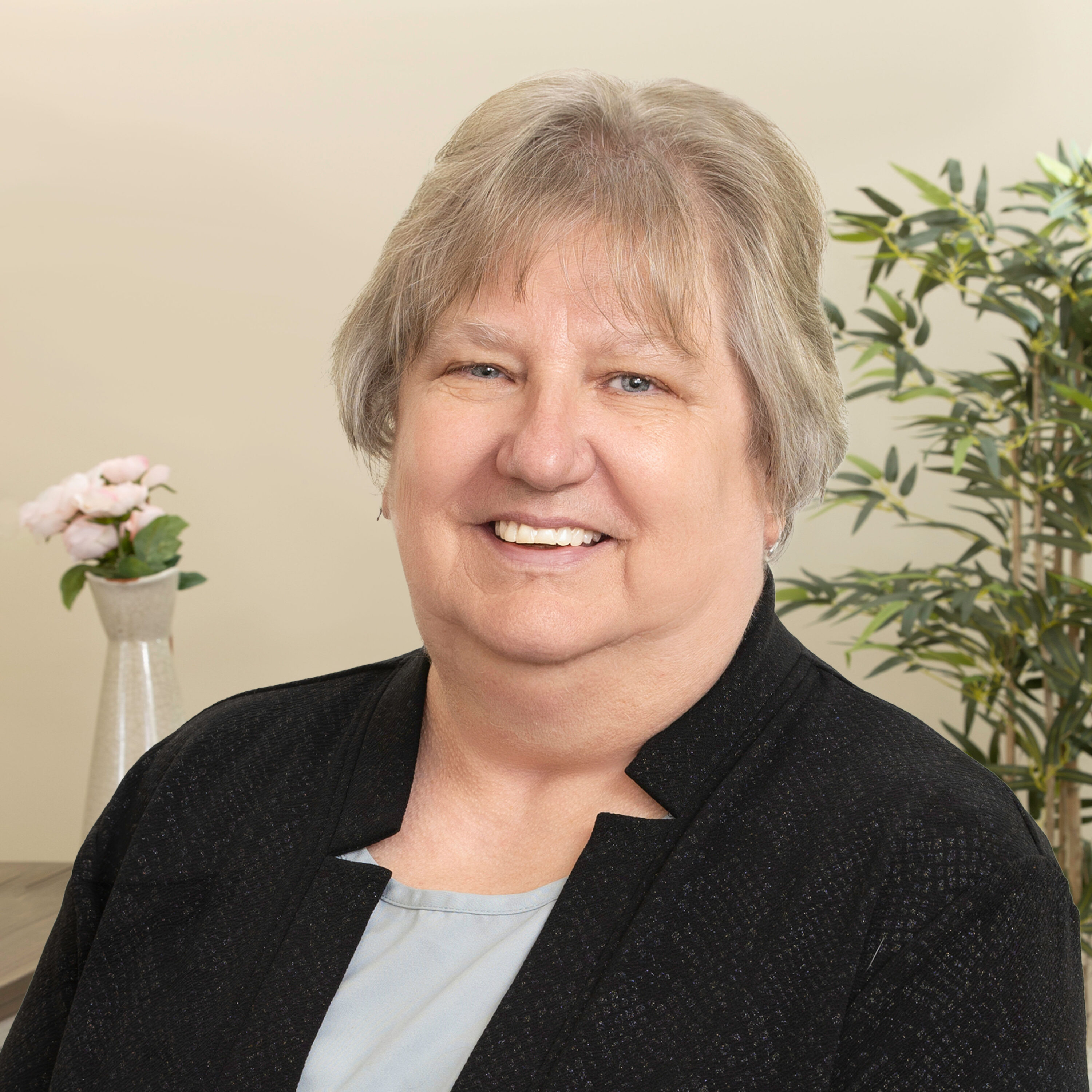 Smiling older woman in black jacket indoors