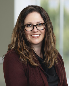 Professional woman with glasses smiling in office setting