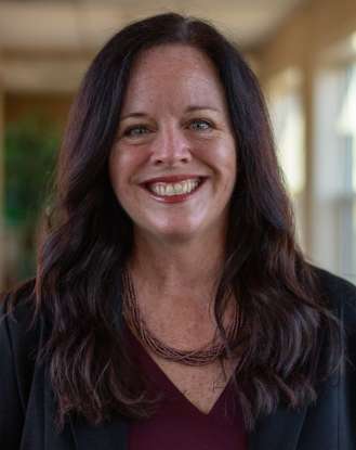 Smiling woman with long dark hair indoors