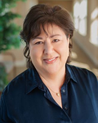 Smiling woman in navy blouse indoors