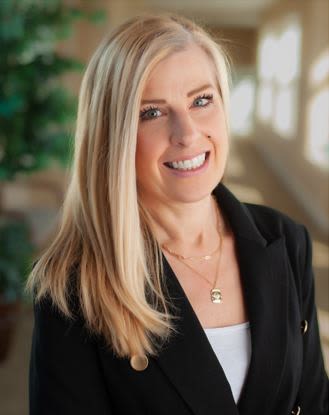 Smiling professional woman in black blazer indoors