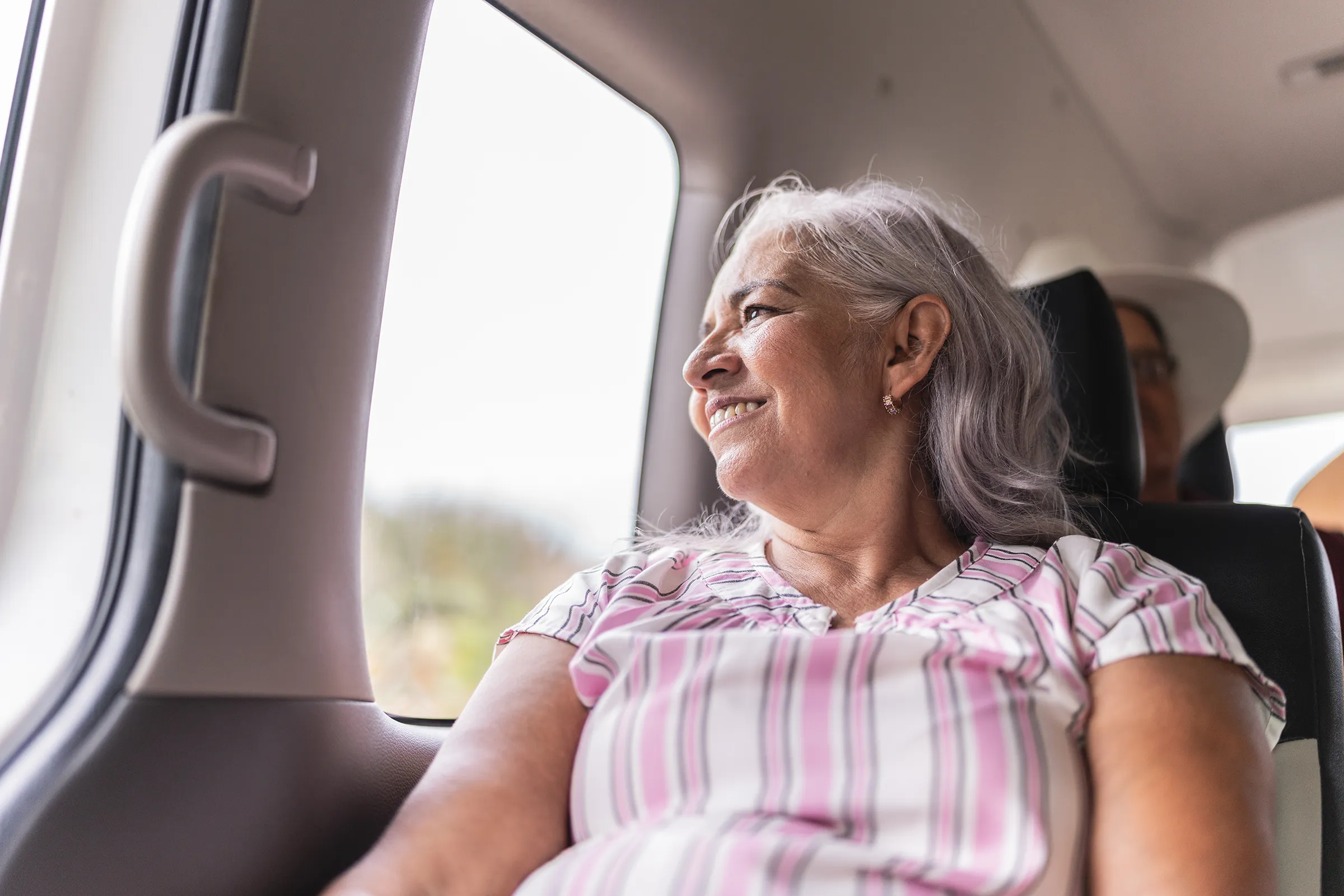 Smiling older woman sitting by a car window