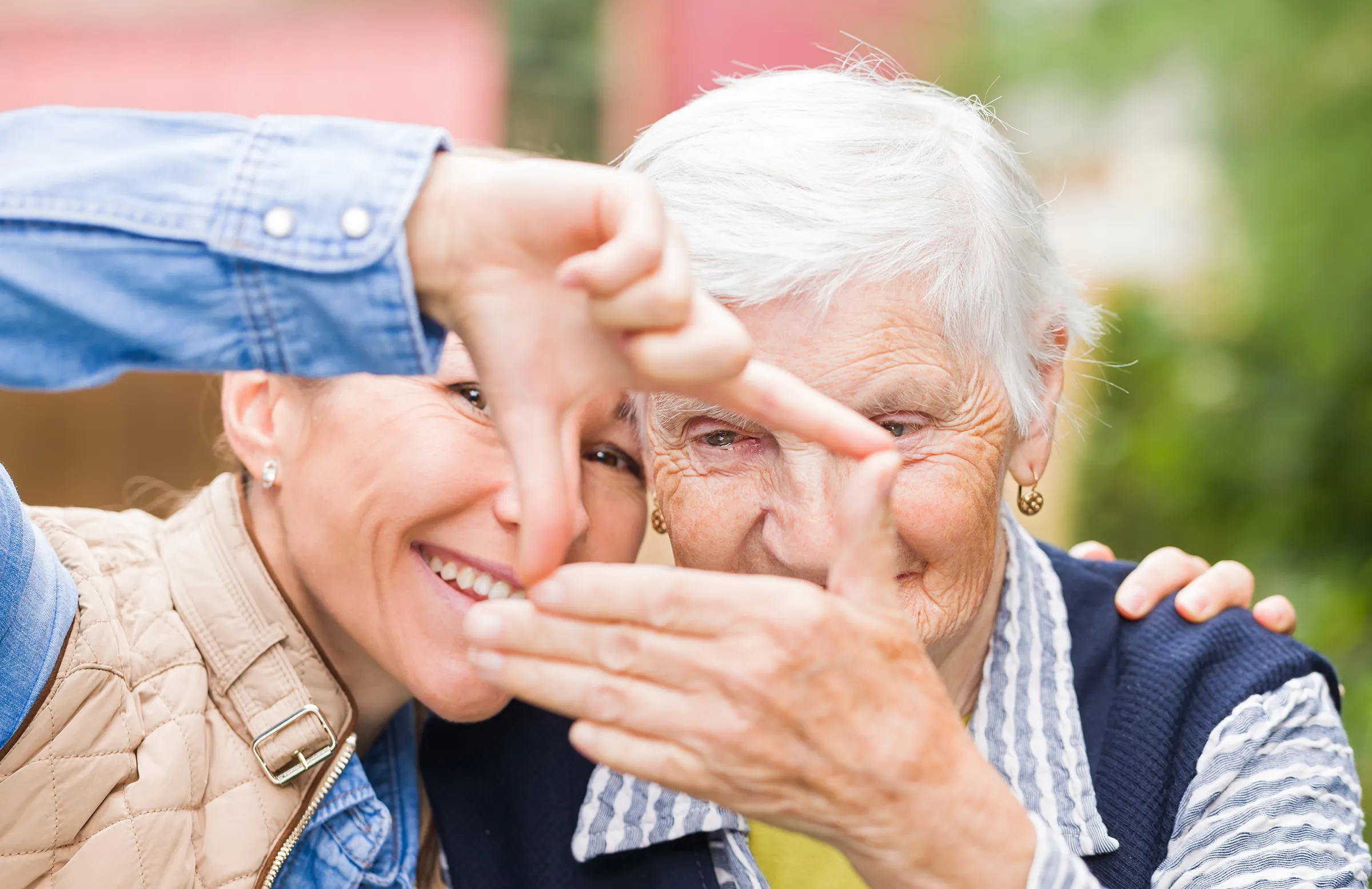 Mother and daughter forming heart shape with hands