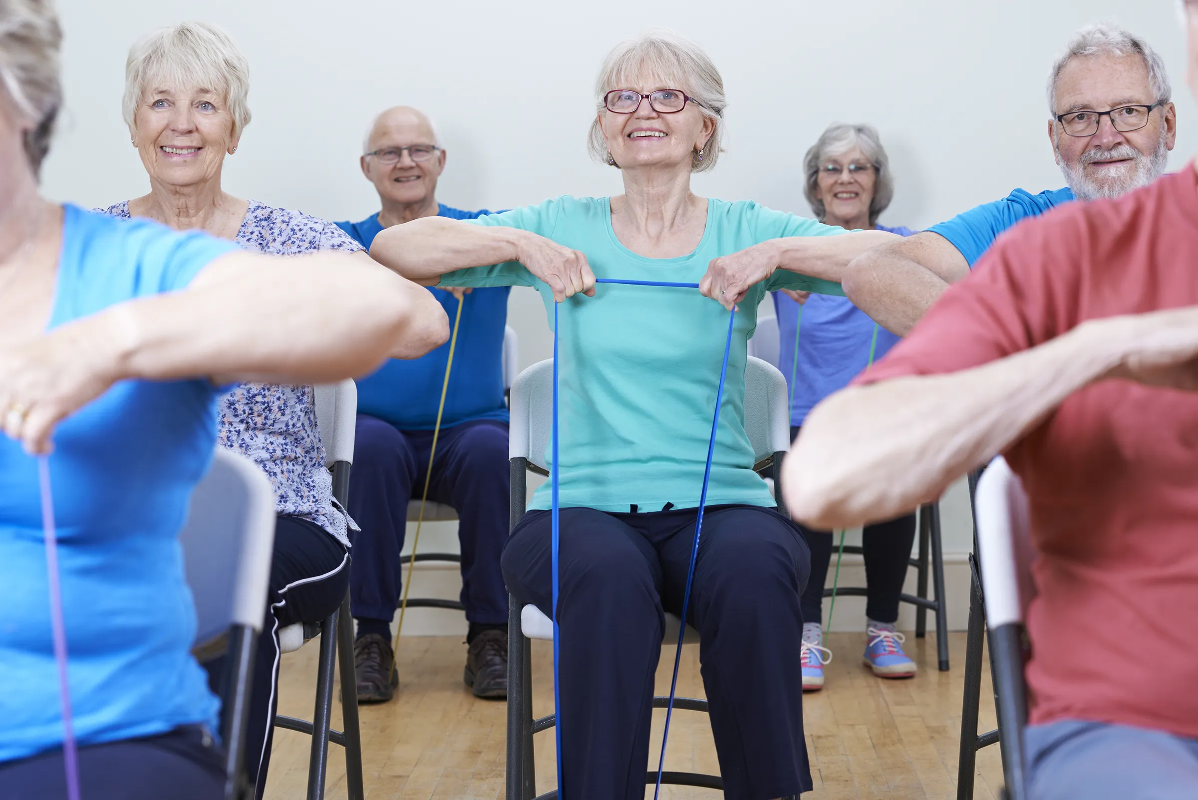 Seniors exercising with resistance bands in chairs